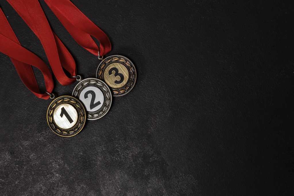 Gold, silver, and bronze medals illustrating performance rankings and trading competition leaderboards for prop firm traders